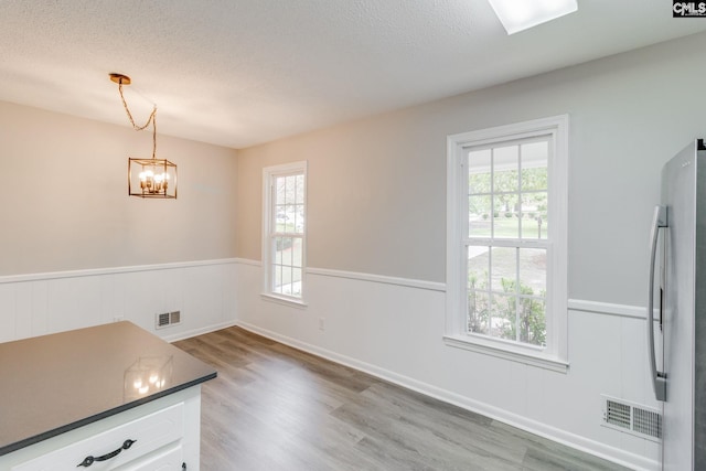 interior space with a chandelier, a textured ceiling, and hardwood / wood-style flooring