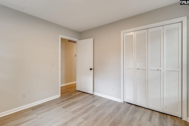 unfurnished bedroom with a closet and light hardwood / wood-style flooring