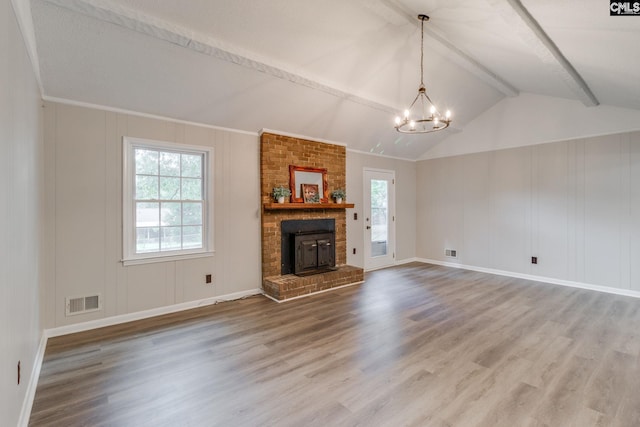 unfurnished living room featuring hardwood / wood-style floors, lofted ceiling with beams, an inviting chandelier, and a brick fireplace