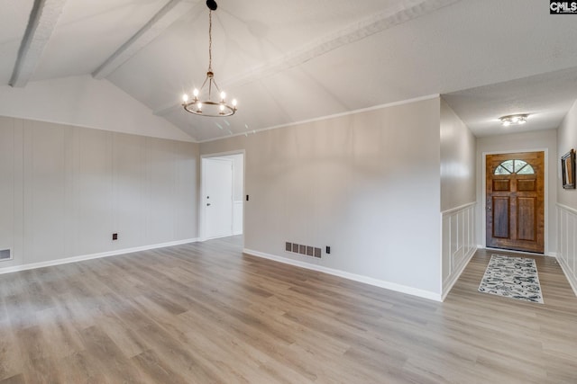 interior space with light wood-type flooring, vaulted ceiling with beams, and an inviting chandelier