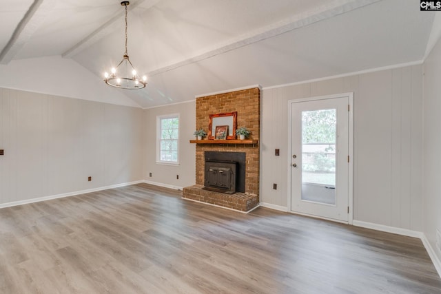 unfurnished living room featuring wood-type flooring, a chandelier, plenty of natural light, and a fireplace