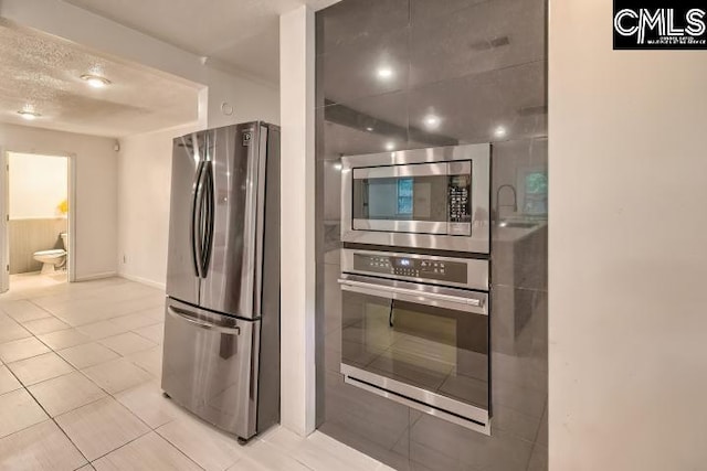 kitchen with light tile patterned floors and stainless steel appliances