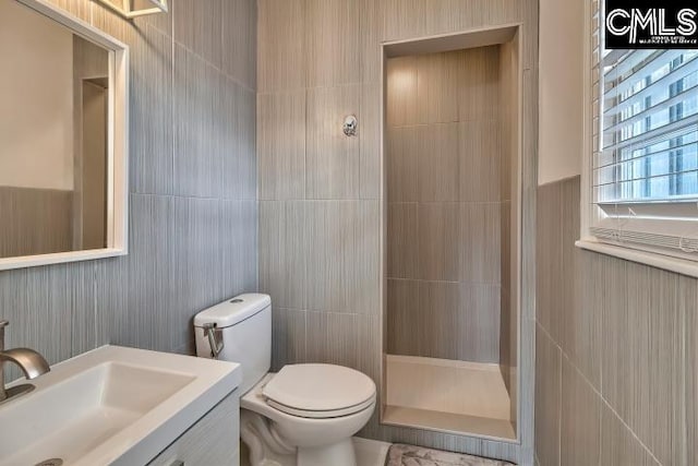 bathroom featuring walk in shower, vanity, and toilet