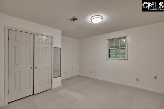 unfurnished bedroom featuring a closet and a textured ceiling