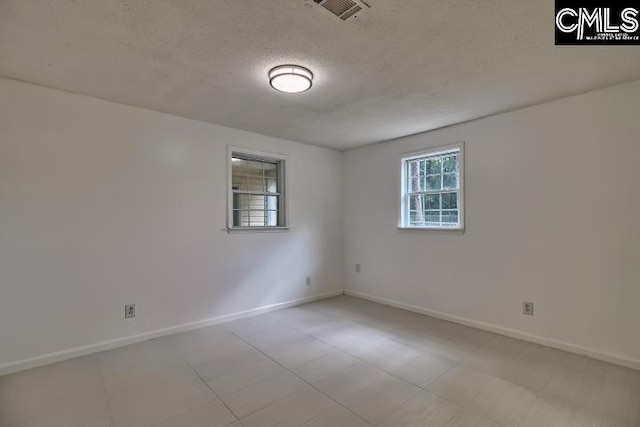 unfurnished room featuring a textured ceiling