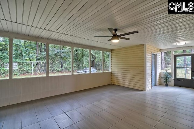 unfurnished sunroom with ceiling fan, wooden ceiling, and a healthy amount of sunlight