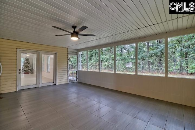 unfurnished sunroom featuring ceiling fan