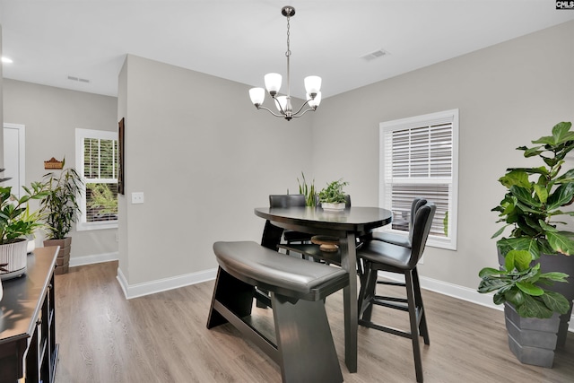 dining area with a notable chandelier and light wood-type flooring