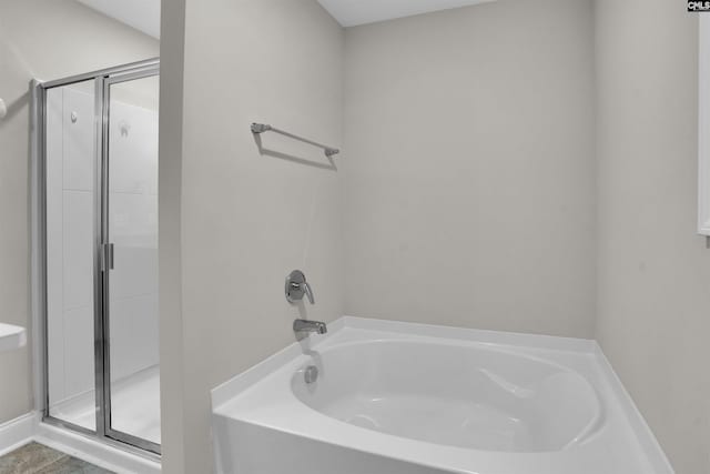 bathroom featuring shower with separate bathtub