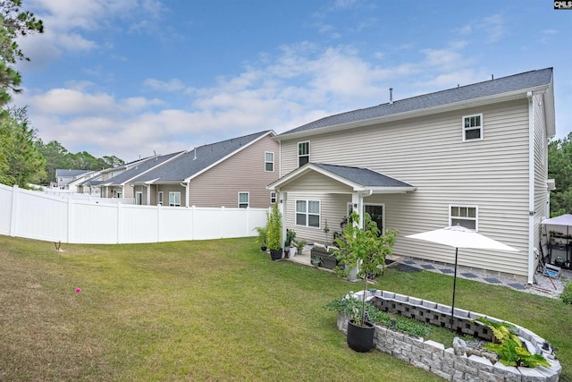 back of house with a lawn and a patio area