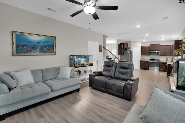 living room featuring light wood-type flooring and ceiling fan