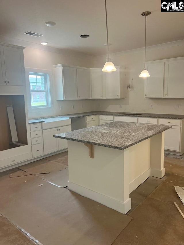 kitchen with white cabinetry, hanging light fixtures, a kitchen bar, and a kitchen island