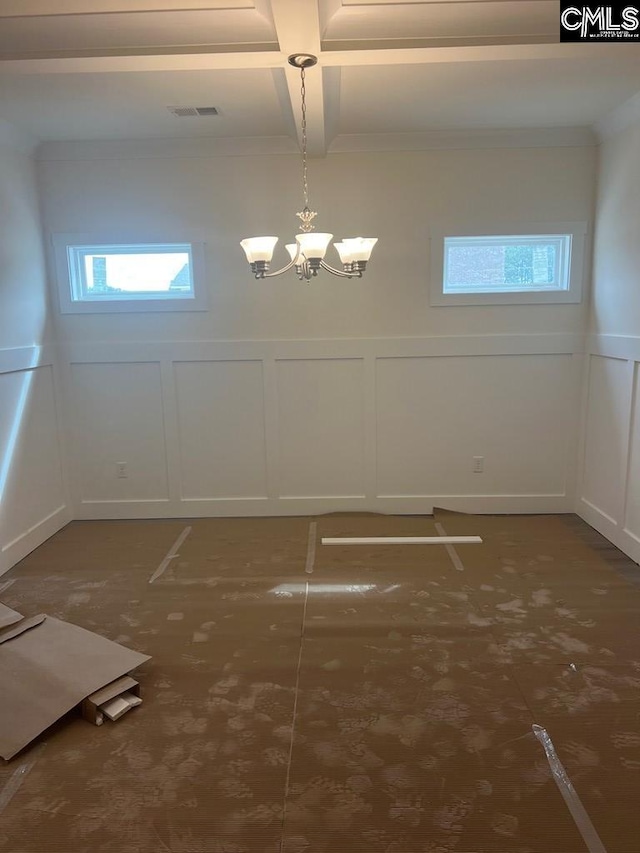 empty room featuring beamed ceiling, coffered ceiling, and an inviting chandelier