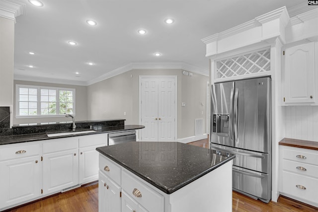 kitchen with a center island, sink, stainless steel appliances, and white cabinets