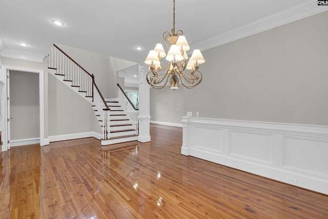 unfurnished dining area with ornamental molding, a chandelier, and hardwood / wood-style floors