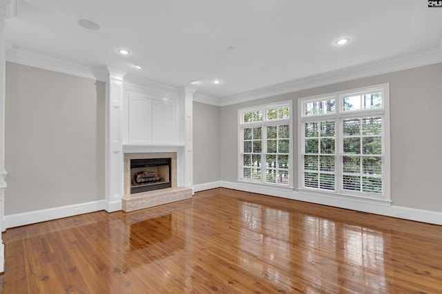 unfurnished living room featuring hardwood / wood-style flooring and crown molding