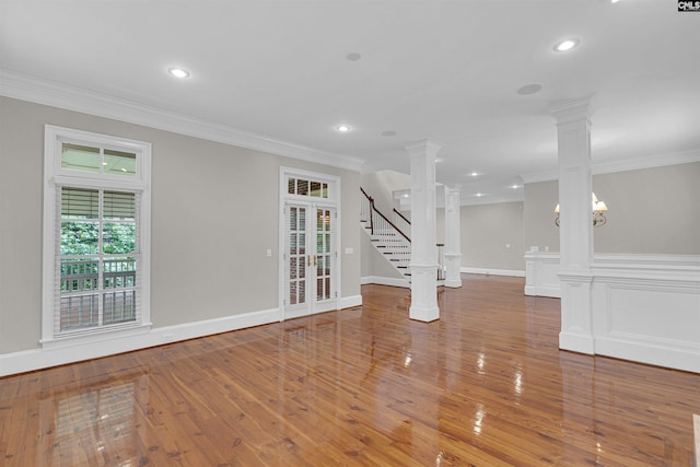 interior space with wood-type flooring, plenty of natural light, crown molding, and ornate columns