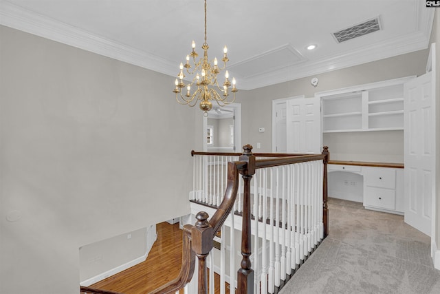 staircase with crown molding, carpet flooring, and a chandelier