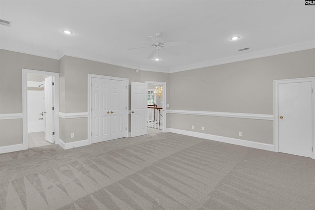 unfurnished bedroom featuring ornamental molding, ensuite bath, light carpet, and ceiling fan