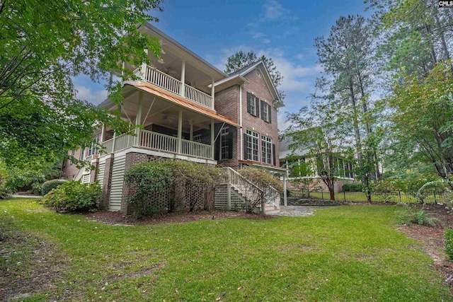 rear view of property with a balcony and a lawn