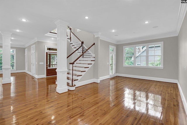 unfurnished living room with ornamental molding, hardwood / wood-style flooring, and decorative columns