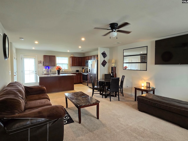 living area with baseboards, recessed lighting, visible vents, and light colored carpet