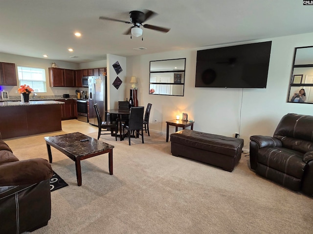 living room with ceiling fan, recessed lighting, and light colored carpet