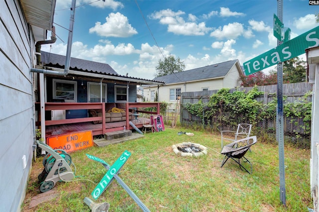 view of yard with a deck and an outdoor fire pit