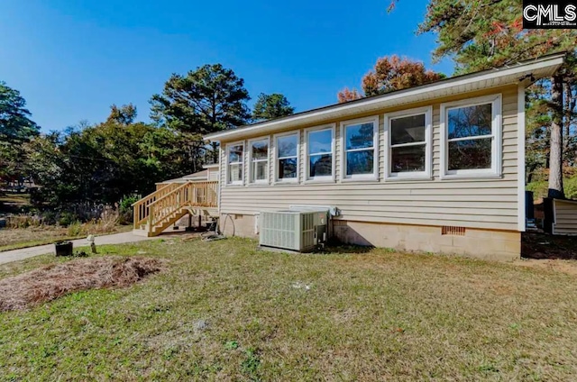 view of front facade featuring a front yard and central air condition unit