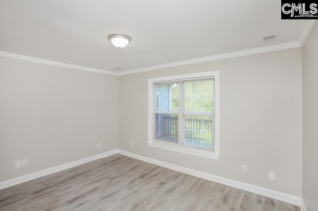 empty room with ornamental molding and light wood-type flooring