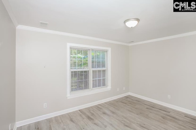 empty room featuring light hardwood / wood-style floors and crown molding