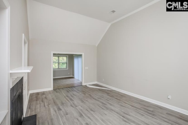 unfurnished living room featuring light wood-type flooring and vaulted ceiling