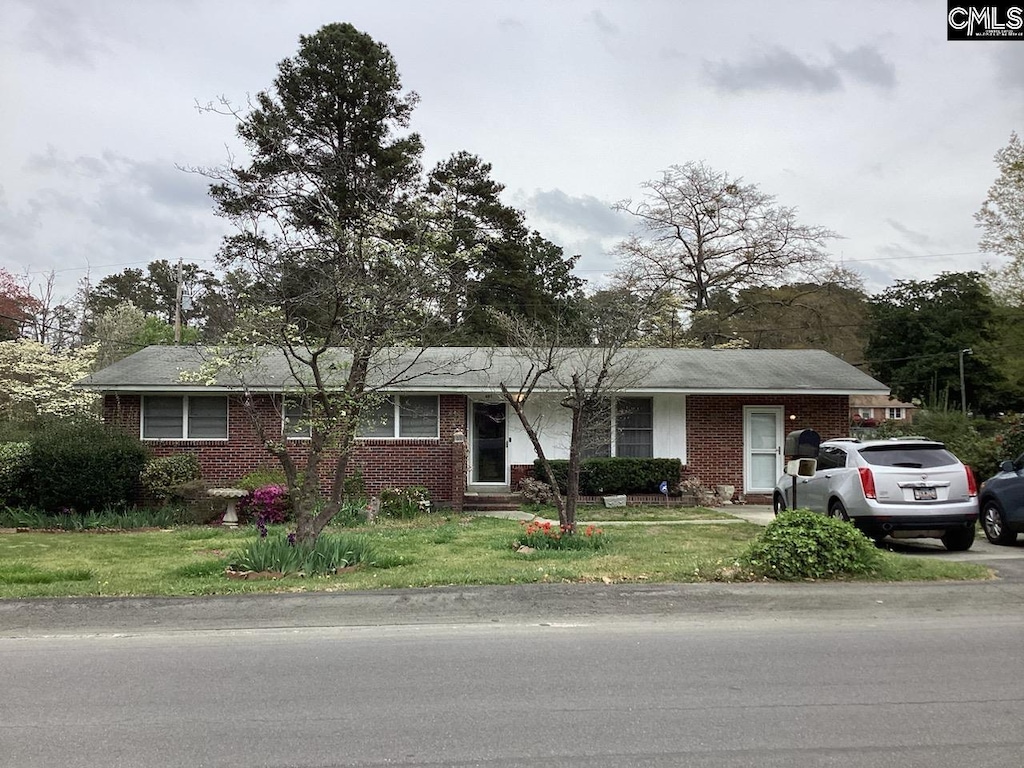 single story home featuring a front yard and brick siding