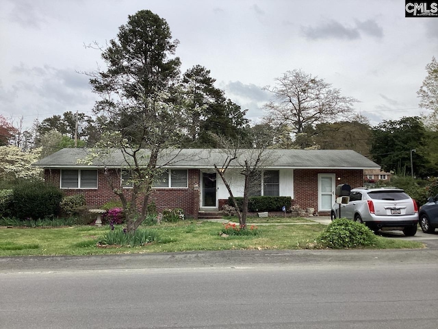 single story home featuring a front yard and brick siding