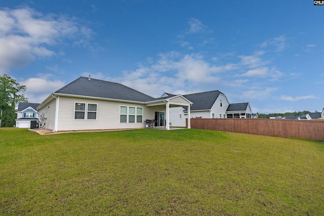 rear view of property featuring a garage and a yard