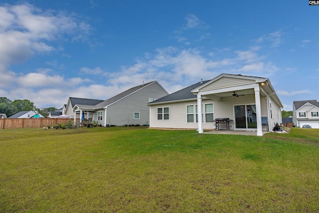 back of property featuring ceiling fan, a lawn, and a patio