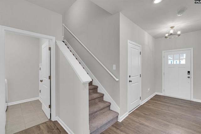 entryway with wood-type flooring and a chandelier