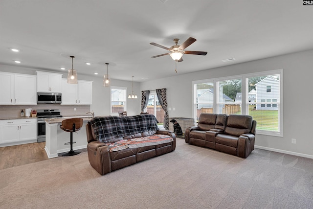 carpeted living room with ceiling fan