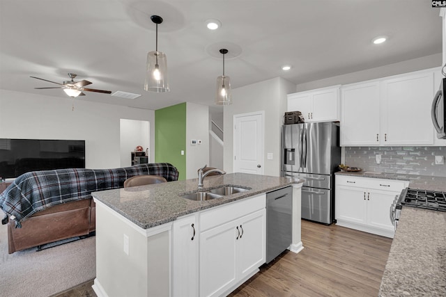 kitchen with ceiling fan, white cabinets, sink, a kitchen island with sink, and appliances with stainless steel finishes