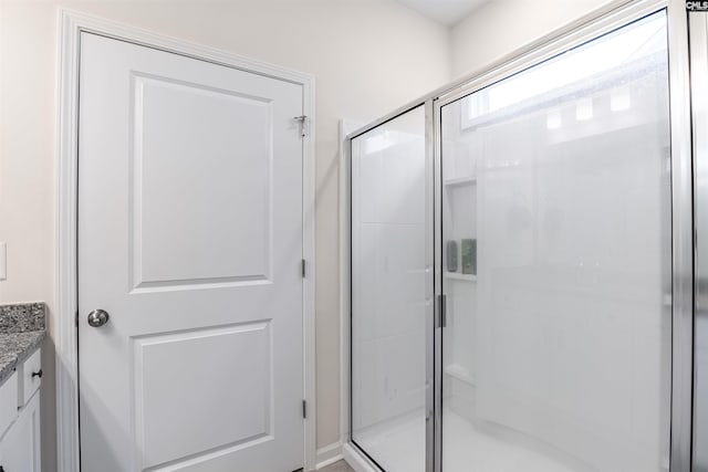 bathroom featuring vanity and a shower with shower door