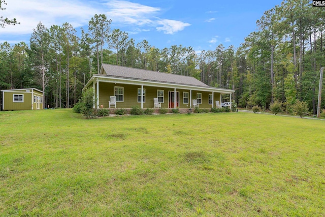 view of front of house featuring a front yard, an outdoor structure, and covered porch