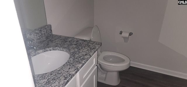 bathroom with vanity, toilet, and hardwood / wood-style flooring