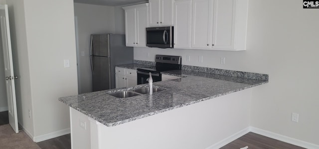 kitchen with white cabinetry, kitchen peninsula, and appliances with stainless steel finishes