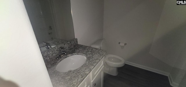 bathroom with wood-type flooring, a shower, vanity, and toilet