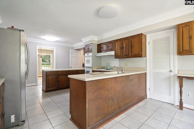 kitchen featuring stainless steel fridge, light tile patterned flooring, kitchen peninsula, white double oven, and ornamental molding