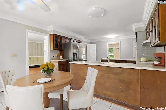 tiled dining area featuring ornamental molding, ceiling fan, and sink