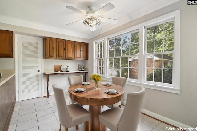 dining space with light tile patterned floors, crown molding, and ceiling fan