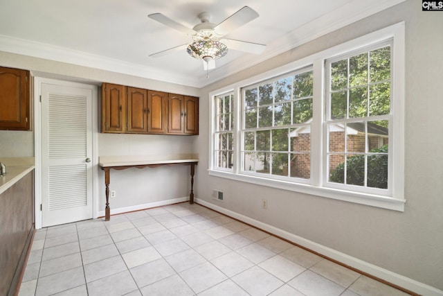 interior space featuring ceiling fan, light tile patterned floors, and crown molding