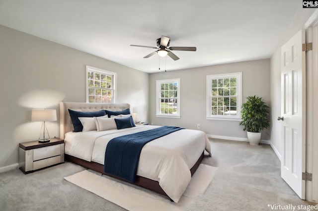 bedroom with multiple windows, light colored carpet, and ceiling fan