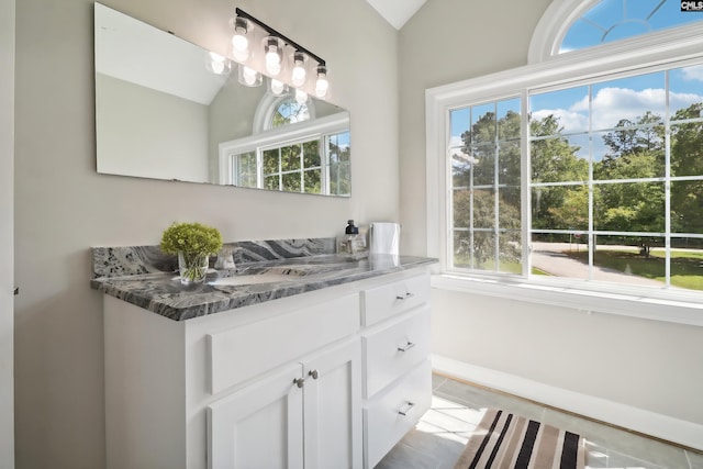 bathroom featuring vanity, vaulted ceiling, and tile patterned floors